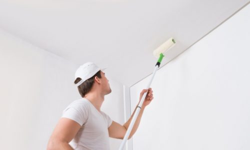 Popcorn ceiling removal services man painting ceiling