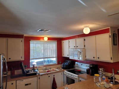 Interior kitchen painting with red walls and white cabinets
