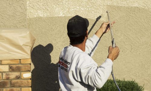 painter refreshing stucco paint