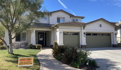 white painted stucco exterior with green garage doors
