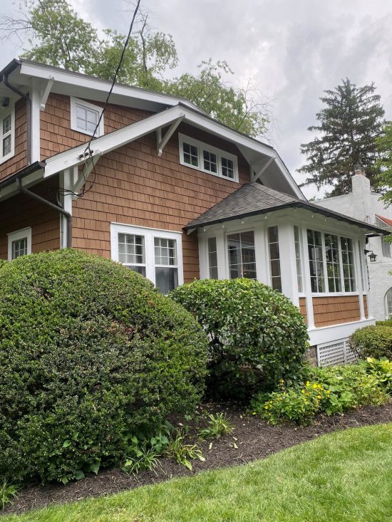 side of house with cedar shake siding and white trim