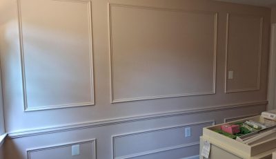 pink painted nursery wall with wainscoting trim