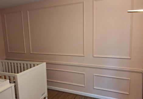 pink painted nursery wall with wainscoting trim