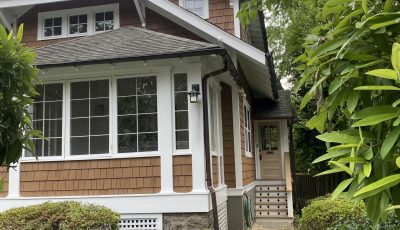 front of house with cedar shake siding and white trim