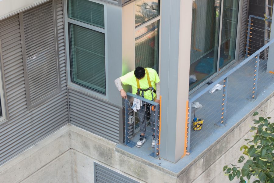 Condo Painting Project arial view with painter touching up balcony gate Preview Image 3