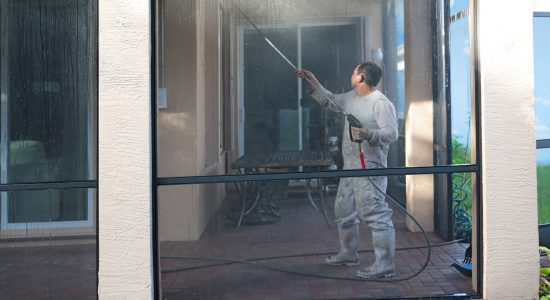 Power washing the side of a house before painting