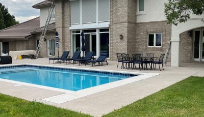brick and stucco home exterior with inground pool