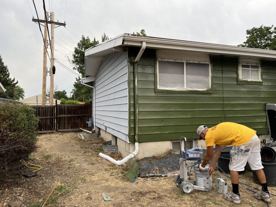 painter next to house with white siding being painted green Preview Image 2