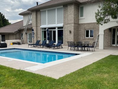 brick and stucco home exterior with inground pool