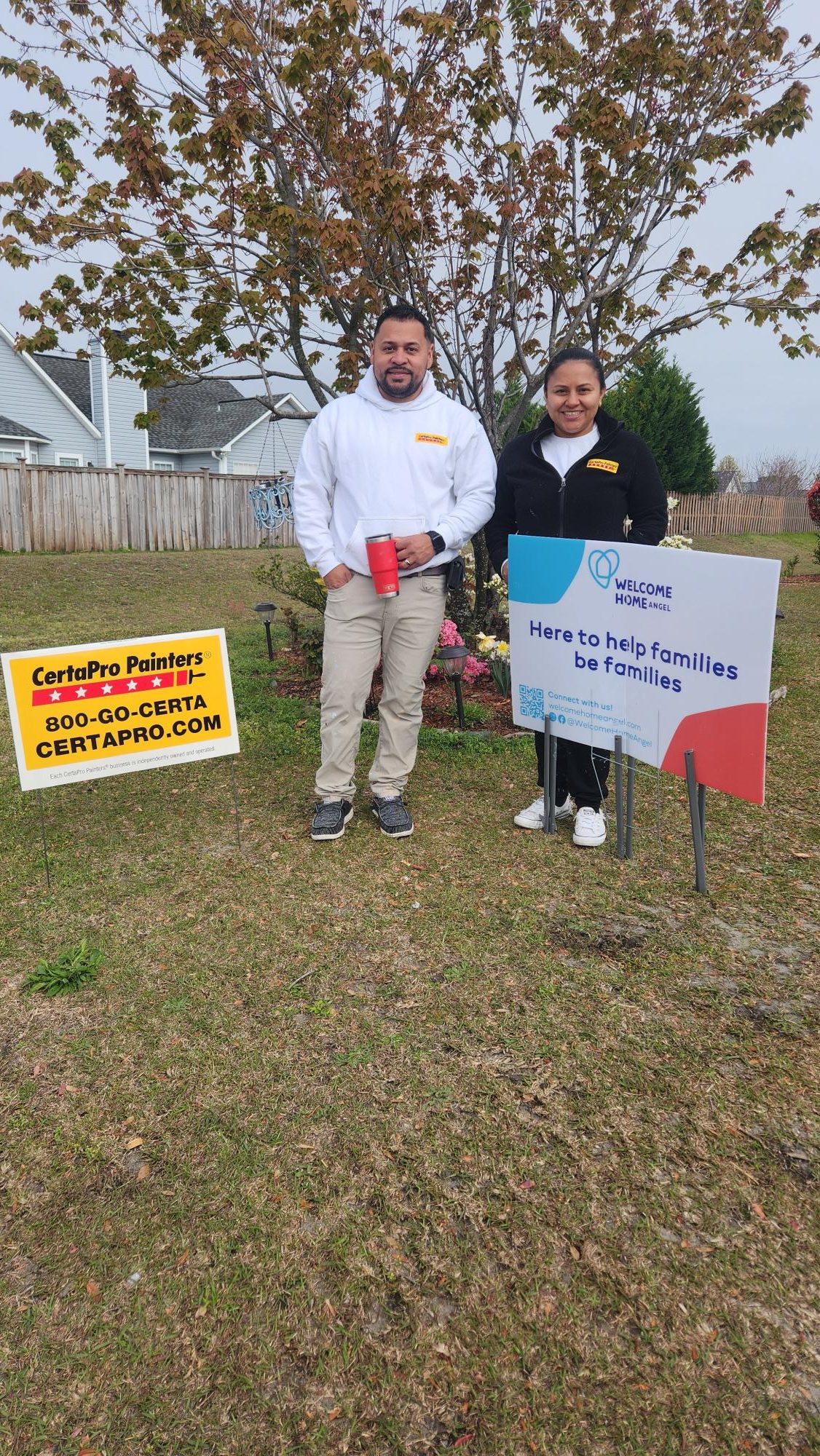 CertaPro painters crew members posing next to welcome home angel sign