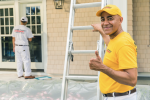 CertaPro painter doing exterior work on house with ladder