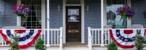 porch with american flag banners and hanging baskets