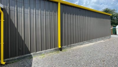 Industrial painting facility with yellow accents and soffits and fascias.