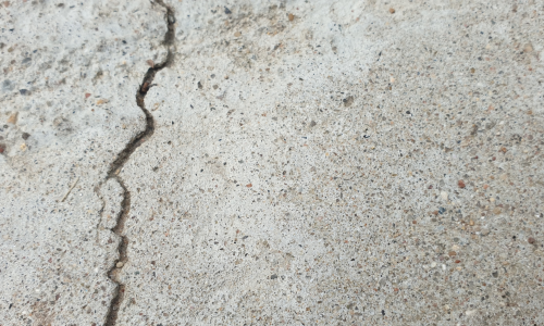 Repair service in cracked and uneven garage floor before epoxy floor repairs by CertaPro Painters of Winston-Salem