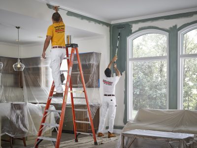 CertaPro Painters painting inside of home and protecting windows.