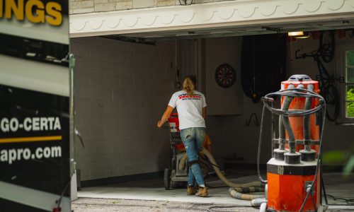 CertaPro Painters of Winston-Salem preparing a garage floor for epoxy sealant with buffer and power wash.