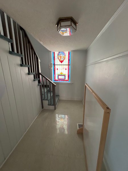 Bottom of stairwell and hallway of lower level brick painting by CertaPro Painters of Winston-Salem Preview Image 5