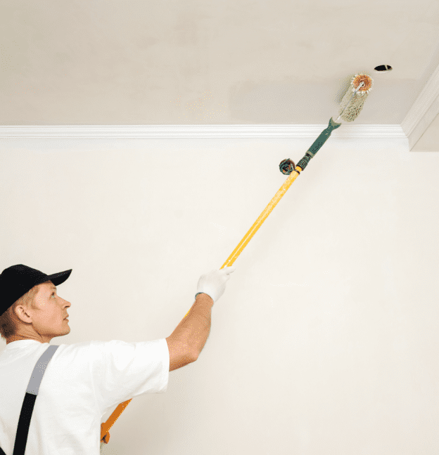Professional painter painting a ceiling with long brush. 