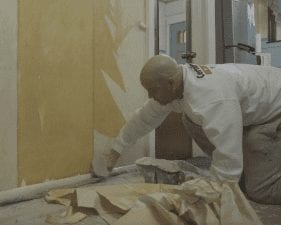 Painter from CertaPro Painters removing wallpaper.