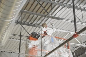 Commercial painter spraying a ceiling.