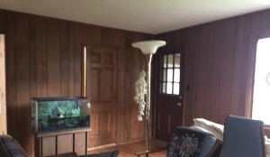 Wood paneling in a living room before being painted.